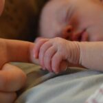 Warum liegen Babys mit Händen nach oben im Schlaf